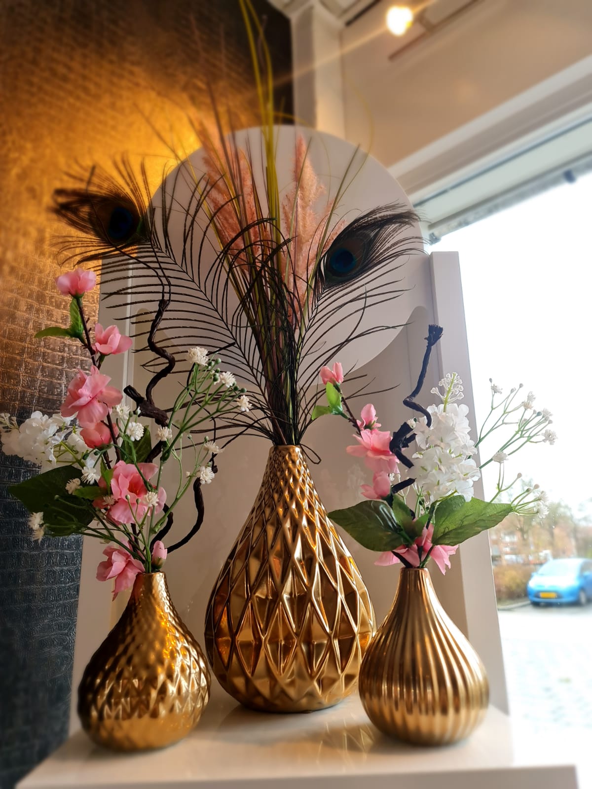 Gouden vazen met bloemen en veren in de salon